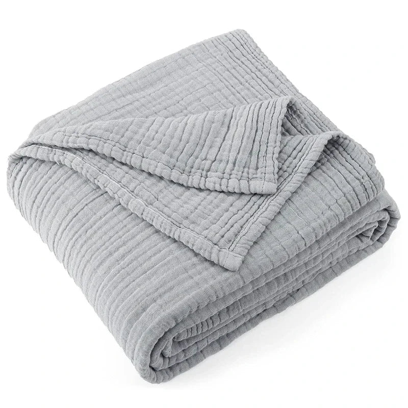 Folded light gray 100% cotton muslin throw