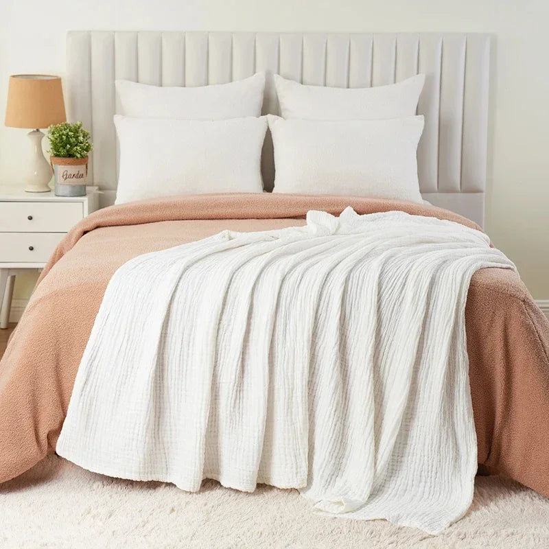 White cotton muslin blanket layered on a bed