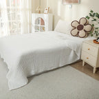 White 100% cotton muslin blanket on a bed