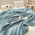 Dusty blue 100% cotton waffle weave blanket on a bed