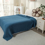 Navy blue 100% cotton muslin blanket on a bed