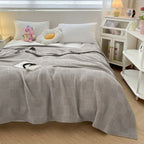 Light gray cotton waffle weave blanket on a bed
