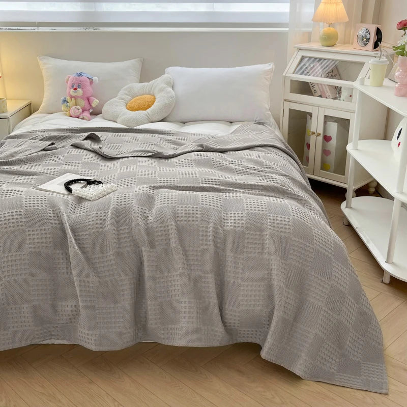 Light gray cotton waffle weave blanket on a bed