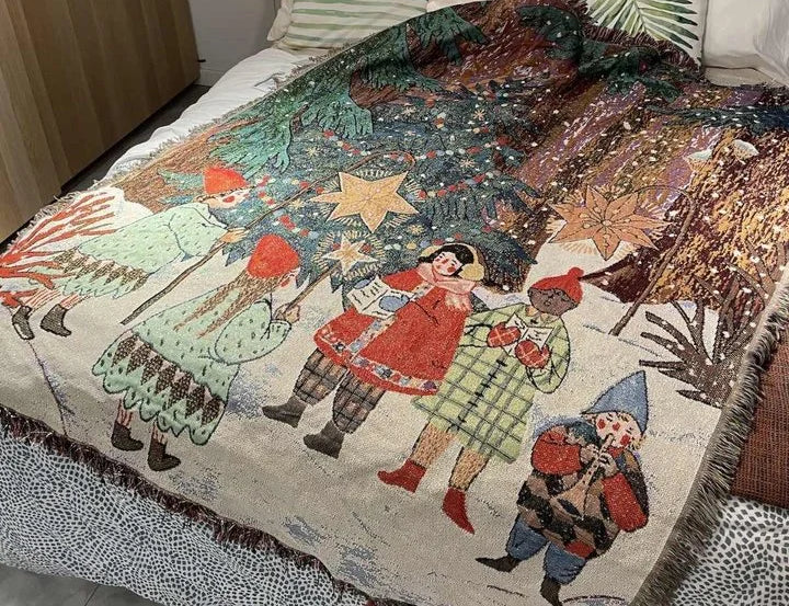 Carolers woven Christmas tapestry throw blanket on a bed