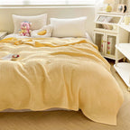 Butter yellow cotton waffle weave blanket on a bed