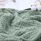 Close-up of crinkly sage green cotton muslin gauze
