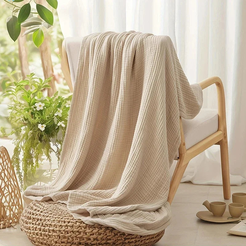 Beige cotton muslin throw on a wooden armchair