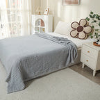 Light gray 100% cotton muslin blanket on a bed