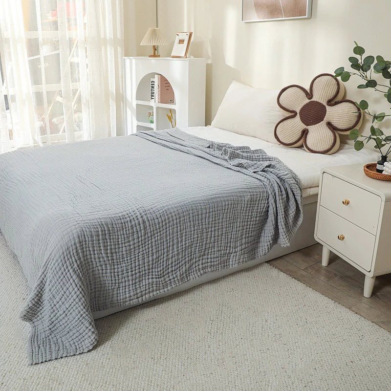 Light gray 100% cotton muslin blanket on a bed