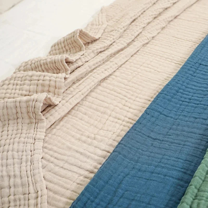 Beige, navy and sage cotton muslin blankets stacked