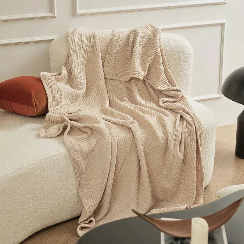 Beige cotton muslin throw draped over a sofa