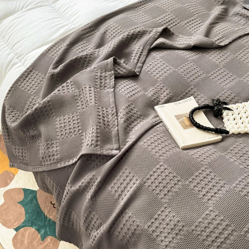 Charcoal gray cotton waffle weave blanket with a book